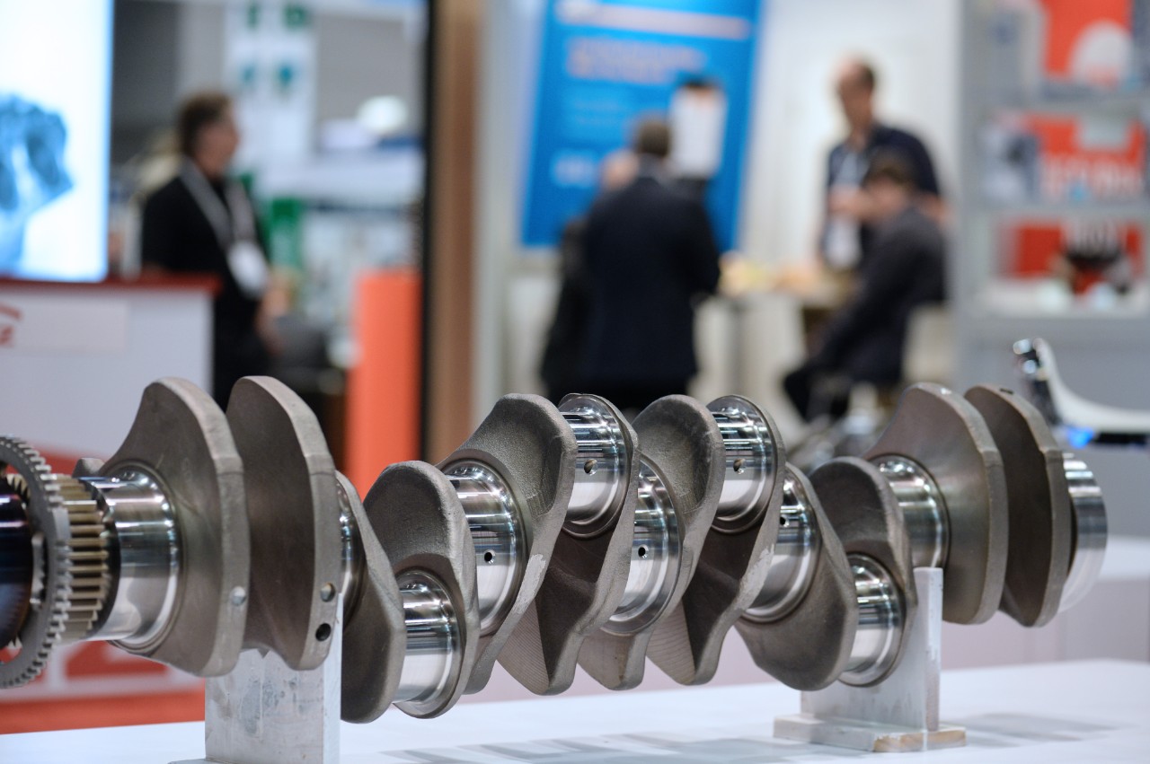 Mobility & Logistics Metal crankshaft on display at a trade show, illustrating automotive engine components and precision engineering