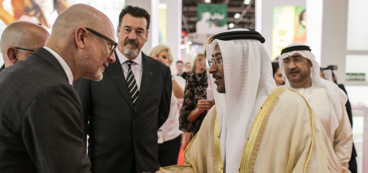 Business leaders greeting and engaging with dignitaries at an international trade fair event, highlighting global business connections